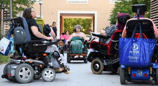 Rollstuhlfahrerinnen stehen beieinander vor der AWO